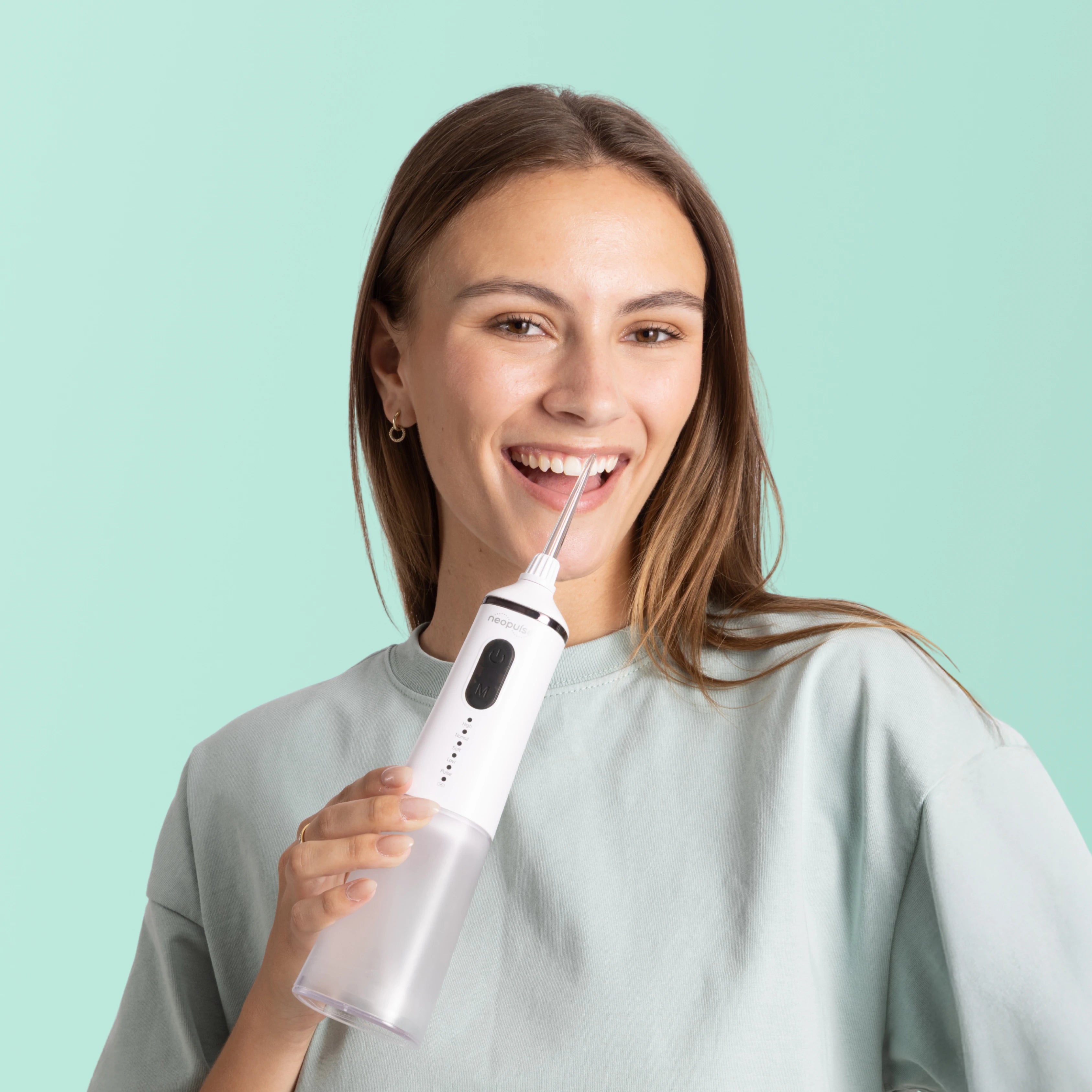 Une femme tient dans ses mains le jet dentaire EASY de la marque NEOPULSE.